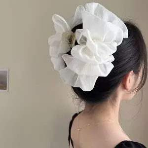 Detailed view of oversized white lace floral hair claw clip on model hair