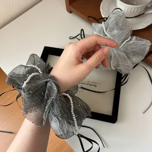 Elegant grey lace scrunchie with pearls and rhinestones shown on hand