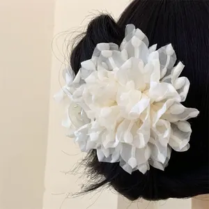 Elegant white chiffon flower hair claw clip on dark hair with textured petal details