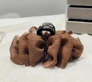 Close-up of a large coffee brown pleated silk hair claw clip with subtle shimmer texture