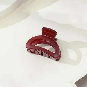 Détail de la pince à cheveux rouge foncé brillante avec ressort métallique solide