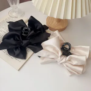 Elegant satin bow hair claw clips in black and champagne colors for women