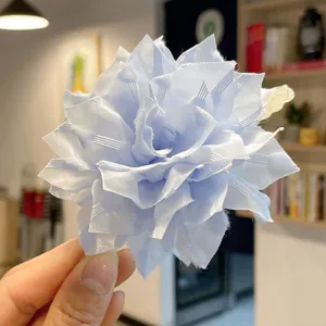 Close-up of light blue fabric flower hair claw with elegant multi-layered petals detail