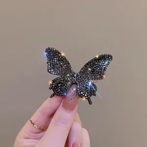 Primo piano di un fermaglio per capelli a farfalla con strass neri e finitura scintillante