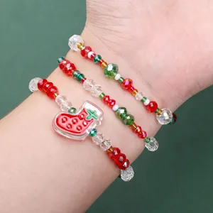 Primer plano de tres pulseras de Navidad con cuentas de cristal y colgante de calcetín