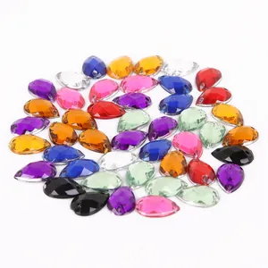 Dettaglio macro di strass in acrilico a goccia colorati con due fori per cucito fai-da-te