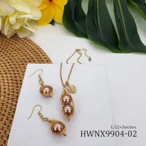Détail de bijoux tropicaux avec perles enveloppées de fil et pendentif feuille dorée