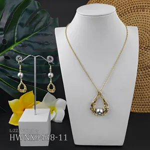 Detail von goldenem Schmuckset mit Perlen und Hawaii-Muster auf einem Büstenhalter