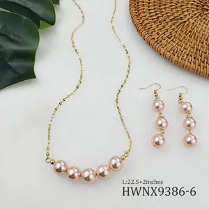 Dettaglio del set collana e orecchini con perle di conchiglia rosa e catene dorate