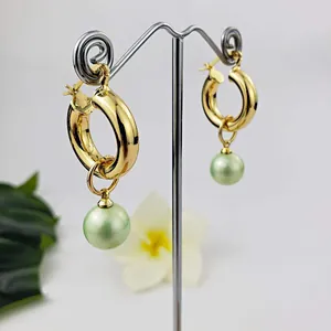 Vintage 18K gold plated hoop earrings with light green pearl drops on a metal stand