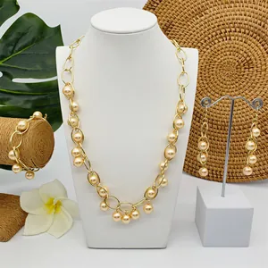 Detail van grove gouden ketting sieradenset met grote parels op een wit display