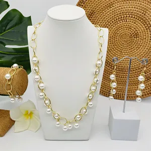 Detailset van tropische parelketting, armband en oorbellen getoond op witte displays