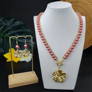 Detail von goldenem Hibiskus Schmuckset mit rosa Perlen und doppellagiger Halskette