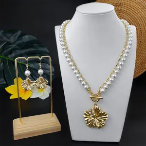 Detailansicht der Halskette mit Gold-Plumeria-Anhänger und Perlenohrringen im Set