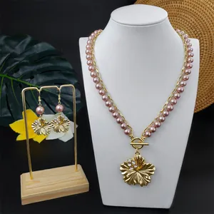Detail von Silberperlenkette und Plumeria-Ohrring-Set auf einem Ausstellungsständer