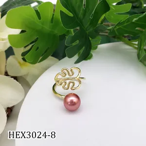 Detail van verstelbare goudkleurige bladring met roze parel op witte presentatie