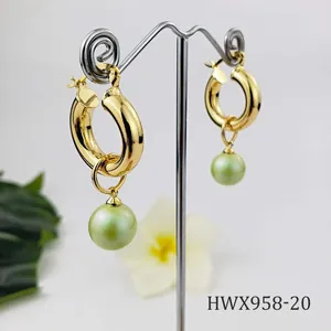 Detailed shot of 18K gold hoop earrings featuring elegant light green pearl pendants