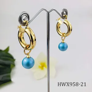 Detail of 18K gold plated hoop earrings featuring a lustrous light blue pearl pendant