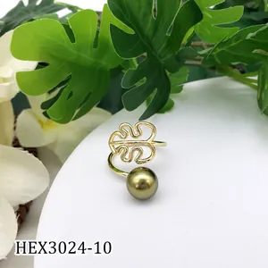 Macro-opname van gouden monstera-ring met een donker olijfgroene schelpparel detail