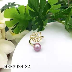 Detail van gouden monstera blad ring met een lavendel parel op witte standaard