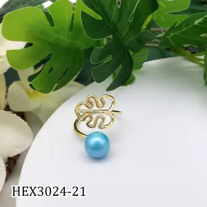 Detailopname van monstera blad goudring met blauwe parel op botanische achtergrond