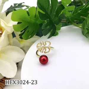 Detail van gouden monstera blad ring met rode parel en verstelbare open ringband