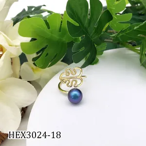 Detailopname van gouden monstera blad ring met paars iriserende schelpparelmoer