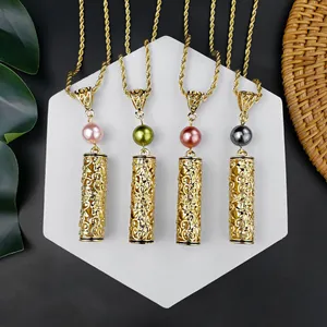 Detail van gouden opengewerkte bloemenhangers met gekleurde parels aan een koordketting