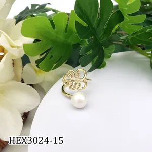 Detail van gouden monstera blad ring met witte parel en open verstelbare band