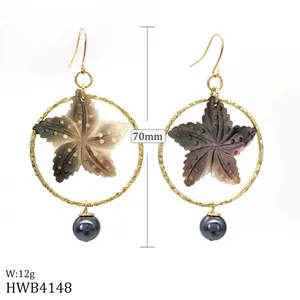 Vue détaillée des boucles d'oreilles étoile de mer 70mm avec anneaux dorés et perles