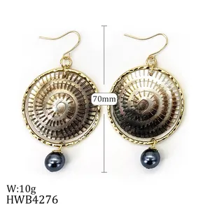 Détail de boucles d'oreilles de 70 mm avec cadre doré, disque en nacre et perles grises