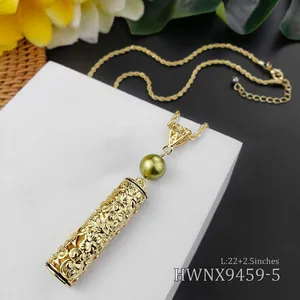 Detail van de boheems goudkleurige holle cilinder hanger met bloemen en een parel