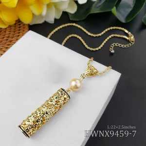 Detailopname van gouden holle hanger met parel aan een gedraaide schakelketting