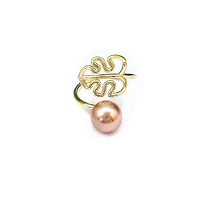 Minimalistische gouden monstera blad open ring met natuurlijke parel op witte achtergrond