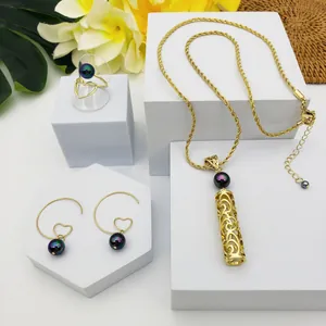 Parure dorée avec pendentif cylindre ajouré, détails en perles et motifs de coeur