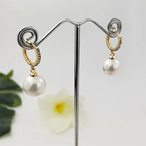 Eleganti orecchini huggie dorati con pietre brillanti e grandi pendenti di perle bianche