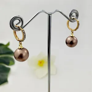 Orecchini huggie in oro con zirconi e pendenti tondi in perle di conchiglia bronzo