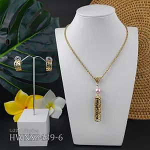 Macro view of tropical hollow cylinder pendants with pink pearls and matching hoop earrings