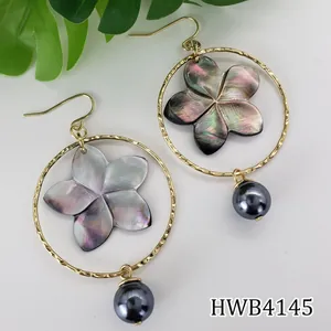 Boucles d'oreilles créoles dorées avec fleur en nacre et perle noire pendante