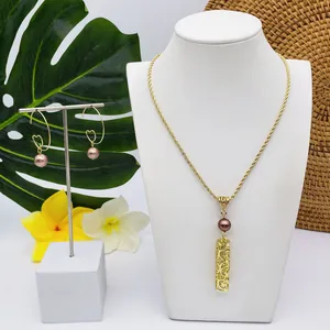 Détail d'un ensemble de bijoux tropicaux avec perles mauves et pendentif doré évidé