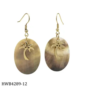 Macro detail of tropical gold coconut tree pendant with oval brown shell earrings