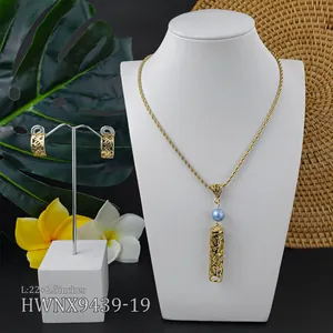 Detailed set of gold hollow pendant necklace with blue pearl and matching earrings