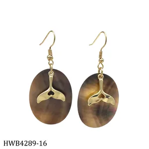 Detail of whale tail metal piece and oval black mother of pearl on dangle earring