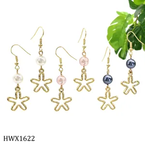 Detailansicht von drei Paar Perlenohrringen mit Sternen in Weiß, Rosa und Marineblau