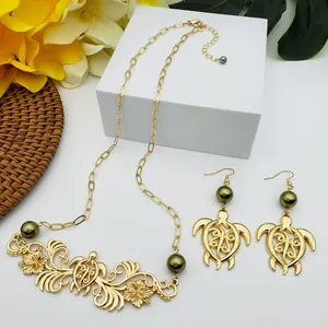Détail du set de bijoux tortue dorée et fleurs avec des perles vert olive élégantes