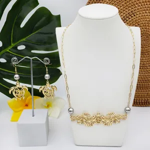 Détail d'une parure bijoux tortue hawaïenne avec perles sur fond de fleurs tropicales
