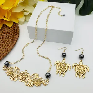 Détail du collier à fleurs tropicales dorées et boucles d'oreilles tortue avec perles