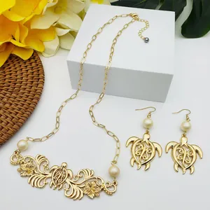 Parure de bijoux dorés exotiques avec pendentifs tortue et fleur et perles blanches