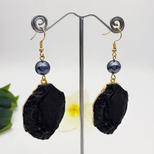 Exaggerated gold plated earrings with dark grey pearls and black volcanic stone drops