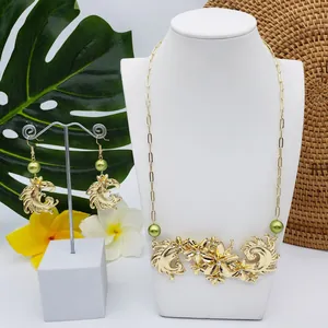Détail du collier floral doré avec perles vertes et strass sur un buste d'exposition